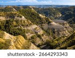 A sweeping panoramic view captures the dramatic landscapes along the Caprock Coulee Trail at Theodore Roosevelt National Park
