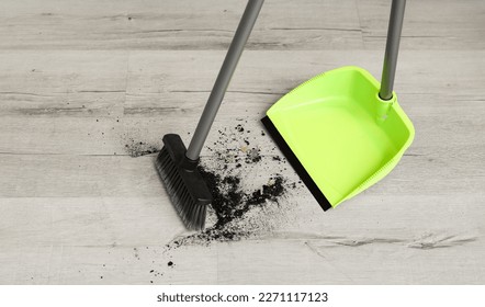 Sweeping of rubbish with dustpan and broom on floor - Powered by Shutterstock