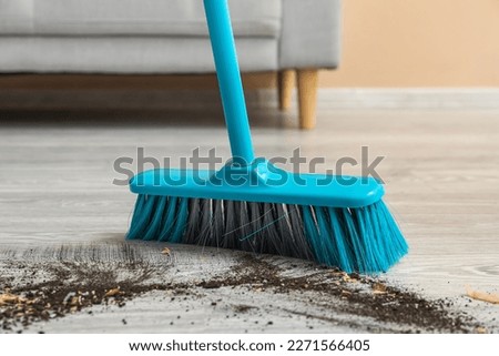 Sweeping of rubbish with plastic broom, closeup