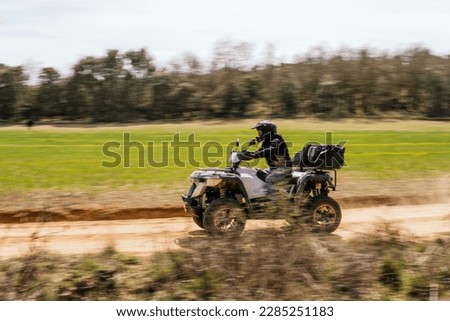 Sweeping stock photo of man riding a quad bike in the countryside