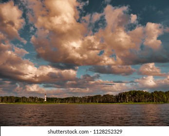 A sweeping view of a dramatic sky and the old Chincoteague Island lighthouse in the distance.