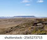 Sweeping view of Square Butte mountain with the sandstone cliffs of the First Peoples Buffalo Jump State Park and National Historic Landmark in the foreground. Photographed near Ulm, Montana.