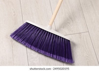 Sweeping wooden floor with bright broom indoors, top view - Powered by Shutterstock