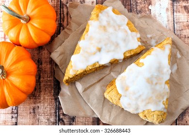 Sweet Autumn Pumpkin Scones With Frosting, Overhead View On Rustic Wood Background
