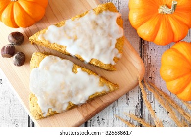 Sweet Autumn Pumpkin Scones With Frosting, Overhead View On Wood Background