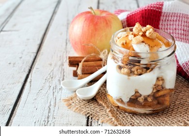 Sweet Baked Apple Parfait In A Mason Jar On A Rustic White Wood Background