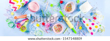 Sweet baking concept for birthday holiday party, cooking background with baking stuff - rolling pin, whipping whisk, cookie cutters, sugar sprinkling, flour. Light blue background, above banner