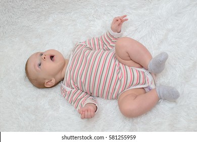 Sweet Beautiful Baby Lying On White Blanket And Very Shocked