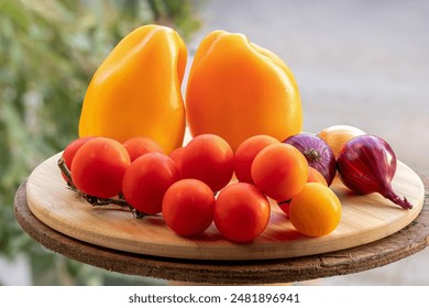 Sweet bell pepper, cherry tomatoes, and onion on round bamboo cutting board. Bell peppers and tomatoes. Vegetable growing, agriculture, vegetable harvesting. - Powered by Shutterstock