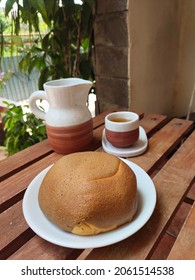 Sweet Bread And A Cup Of Tea On A Wooden Table On The Front Porch Of The House