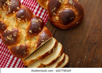 Sweet bread, easter tsoureki cozonac sliced on wood table background, top view. Braided brioche, festive traditional challah