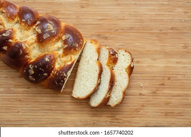 Sweet bread, easter tsoureki cozonac sliced on wood table background, top view. Braided brioche, festive traditional challah