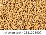 Sweet breakfast cereal rings as background, top view. Healthy breakfast. Cereal background. Whole grain oat cereals.