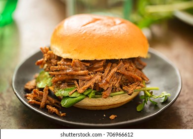 Sweet bun barbecue beef brisket with watercress leaves. Whisky barrel chip smoked British beef brisket with smoky barbecue sauce