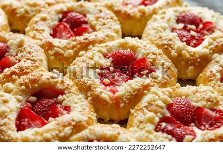 Sweet buns with the addition of strawberries and butter crumble, close up