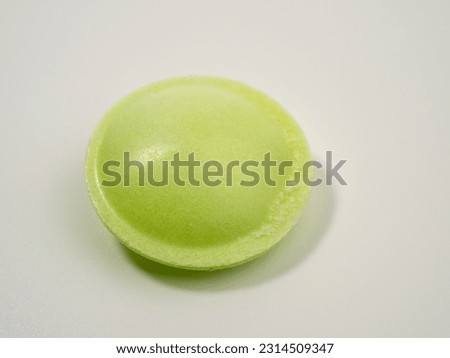 Sweet candies in the shape of a UFO in different colors on a white background. Flying saucers sugar paper in the shape of a spaceship with sherbet.