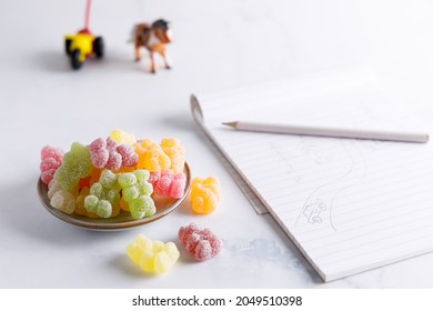 Sweet Candy,colorful Sour Bears Made From Sugar And Jelly On A Table Top With A Child’s Drawing.