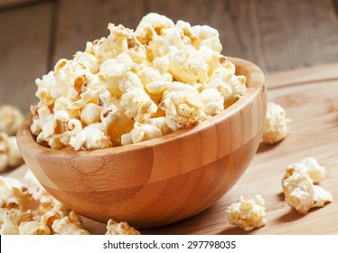 Sweet caramel popcorn in a wooden bowl, selective focus