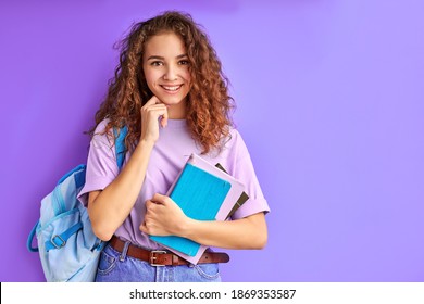 süße, kaukasische junge Studentenmädchen, die bunte Trainingsbücher halten und bereit sind zu studieren