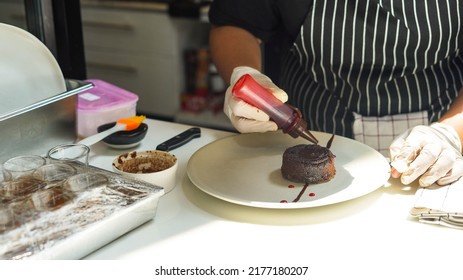 Sweet Chef Prepare Bake And Decorate Tasty Dessert Chocolate Cake On Dish For Customer Made To Order In The Kitchen Or Restaurant As Food Concept