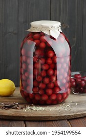 Sweet cherries compote canned in plastic free jar on wooden rustic pantry background, closeup, food storage solution, canned produce, batch cooking, saving leftovers, plastic free eco friendly concept