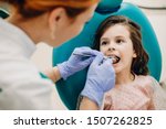 Sweet child doing a teeth examination by a professional specialist in a pediatric stomatology.