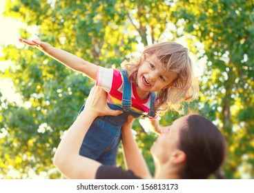 Sweet Child Playing Airplane With Her Mom. Tilt Shift Effect.