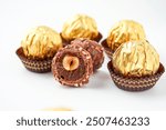 Sweet chocolate balls is made. Chocolate candy in gold wrapper on white background