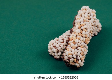 Sweet Chocolate Bars Coated With Corn Cereals And Peanuts Pieces On Green Background.