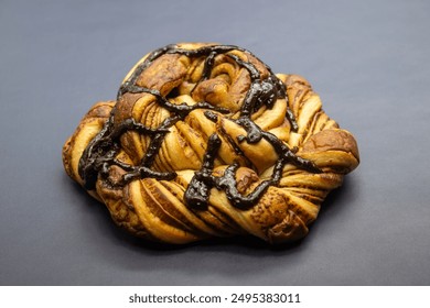 sweet chocolate bread in polygon shape with isolated chocolate topping on a black background 