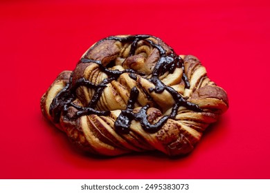 sweet chocolate bread in polygon shape with isolated chocolate topping on a red background 