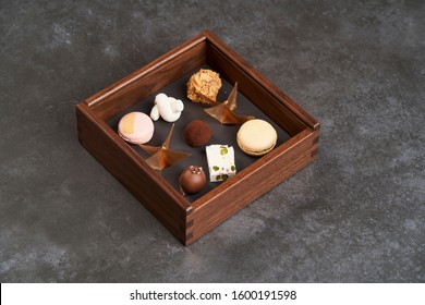 Sweet Chocolate Candies In Wooden Box, Close-up. A Set Of Assorted Chocolates In A Square Box On Dark Background With Copy Space. Valentines Day Gift Box With Chocolate 