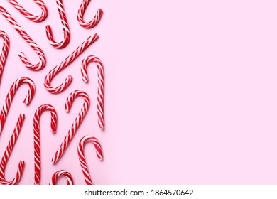 Sweet Christmas Candy Canes On Pink Background, Flat Lay. Space For Text