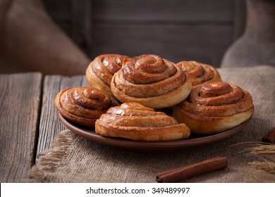 Sweet Cinnamon Bun Rolls Christmas Homemade Delicious Sweet Iced Dessert On Vintage Woonde Table. Traditional Swedish Kanelbullar Baked Pastry