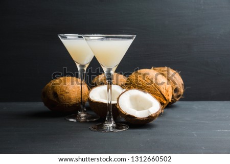 Sweet coconut cocktail in martini glass on the wooden background. Selective focus. Shallow depth of field. 