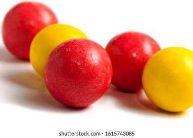 Sweet colorful caramel round candies red and yellow on a white background. Delicious balls with fruit filling.