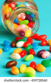 Sweet Colorful Jelly Beans Falling From A Jar, Blue Background