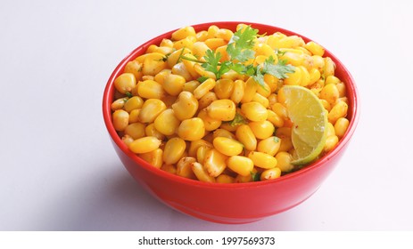 Sweet Corn Chat Or Steamed Yellow Sweet Corn, Chat Masala And Lemon, Served In Red Bowl. Indian Chat Or Snack. Sweetcorn Or Sweet Corn On Isolated White Background