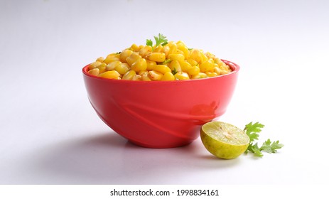 Sweet Corn Chat Or Steamed Yellow Sweet Corn, Chat Masala And Lemon, Served In Red Bowl. Indian Chat Or Snack. Sweetcorn Or Sweet Corn On Isolated White Background