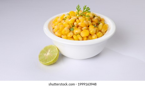 Sweet Corn Chat Or Steamed Yellow Sweet Corn, Chat Masala And Lemon, Served In White Bowl. Indian Chat Or Snack. Sweetcorn Or Sweet Corn On Isolated White Background