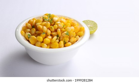 Sweet Corn Chat Or Steamed Yellow Sweet Corn, Chat Masala And Lemon, Served In White Bowl. Indian Chat Or Snack. Sweetcorn Or Sweet Corn On Isolated White Background