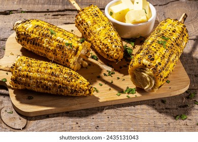 Sweet corn grilled with butter, cheese, cilantro and herbs. Vegetarian, healthy, clean eating barbeque food. Portioned bbq grill corn cobs on rustic wooden background - Powered by Shutterstock