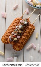 Sweet cornmeal sticks on white wooden background. Waffle pattern and yummy chocolate topping with marshmallow.