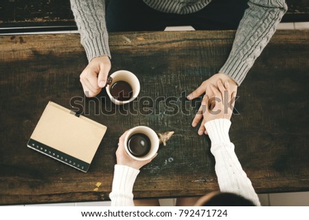 sweet couple having a coffee time while holding hands.