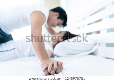 Sweet couple lying down on bed and having sex. focus on hands