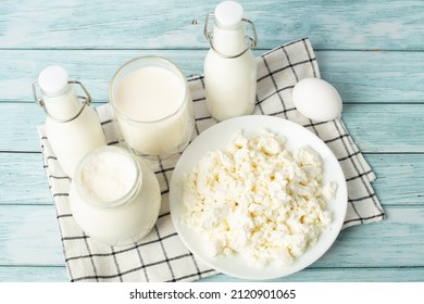 sweet cream in a jar, milk, cottage cheese, an egg on a blue background. milk products.