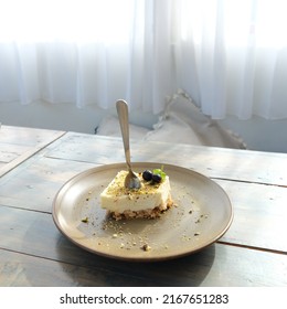 Sweet Creamy Dessert With Blueberry And Cookie Crumbs Garnish On A Ceramic Plate Placed On Wooden Table