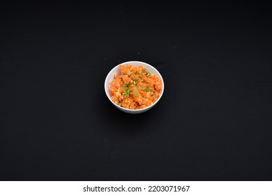 Sweet Desert Known As Halwa Kept On A Bowl Against A Plain Black Background