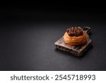 Sweet dessert danish covered with chocolate cream, with cream filling on a dark concrete background