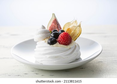 Sweet dessert, Pavlov's cake with butter cream and raspberry, blueberry, fig. Soft focus background